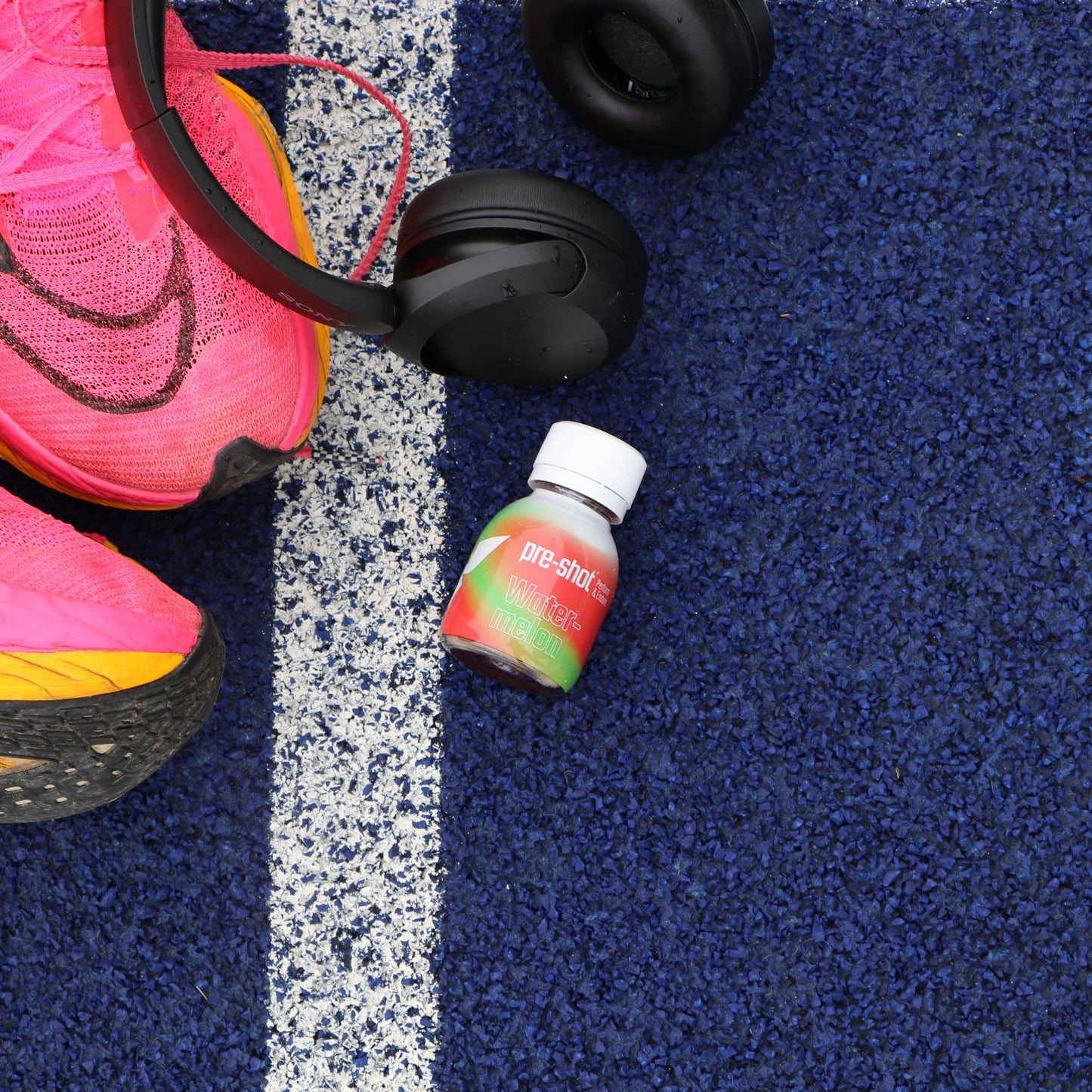 a pair of sneakers and a bottle of water on a blue carpet